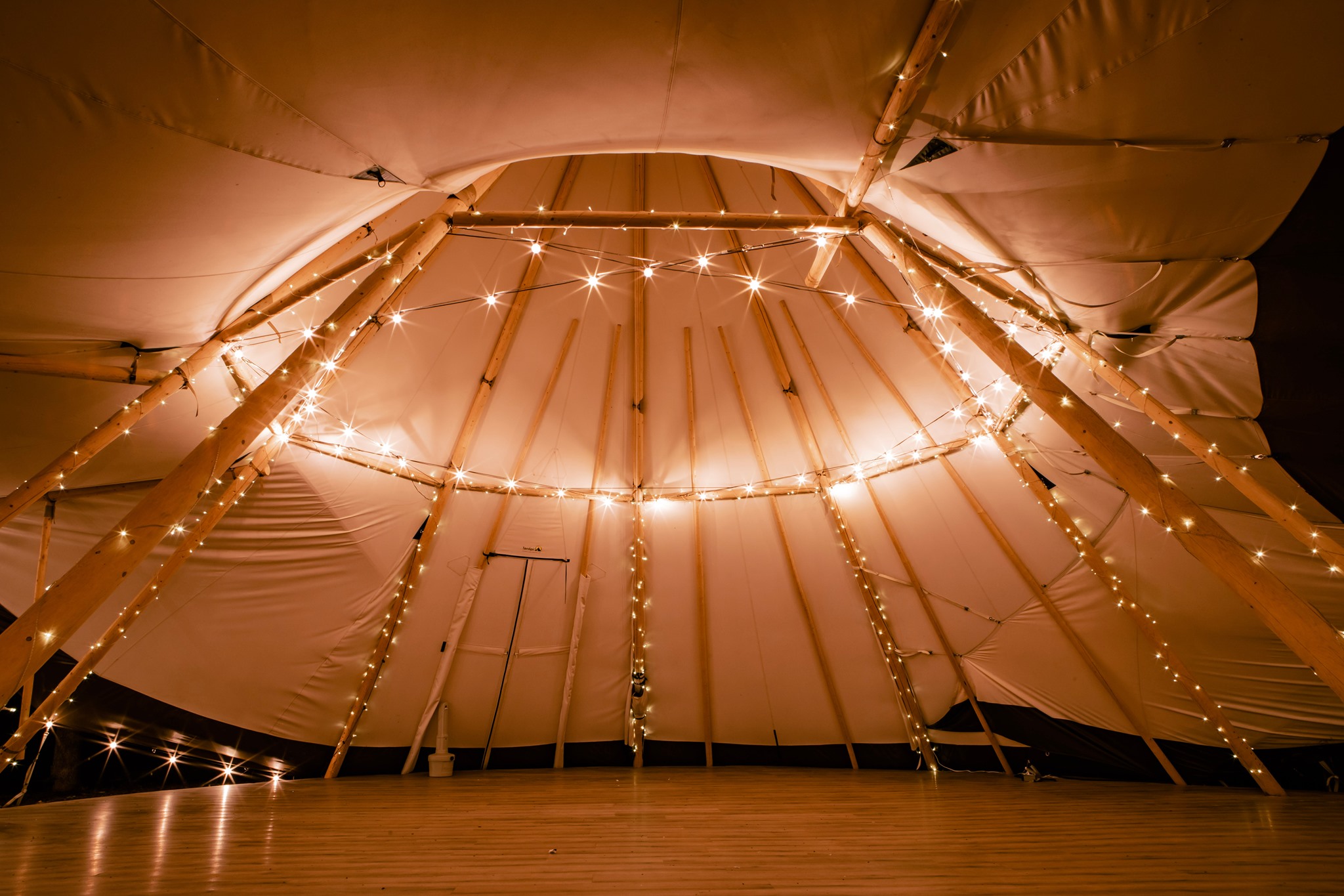 A teepee tent illuminated by whimsical string lights, perfect for unforgettable Texas wedding venues.